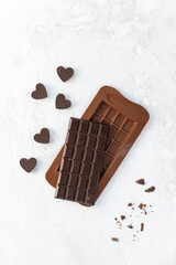 A bar of dark homemade chocolate with hearts. Vertical orientation, top view. Sugar, lactose and gluten free.