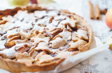 Traditional apple pie on the table with decorations.