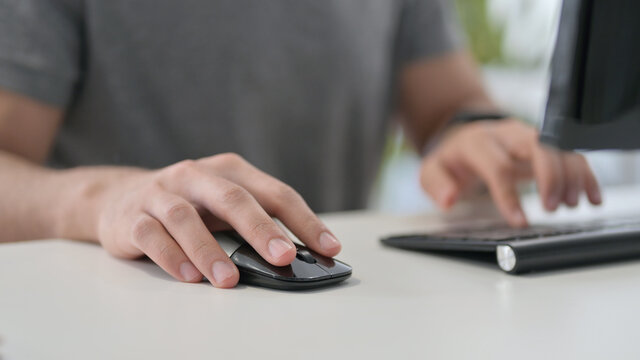 Hands of Young Man Using Mouse on Desktop, Close Up 