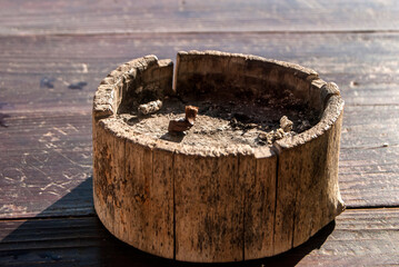 Wooden ash tray with cigarette butt closeup