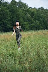 Naklejka na ściany i meble woman outdoors High grass runs across the field for summer 