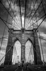 Vertical view from below of Brooklyn Bridge - a hybrid cable-stayed/suspension bridge in New York City, spanning the East River between the boroughs of Manhattan and Brooklyn. Black and white photo.