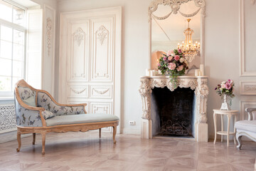 Luxurious light interior of the living room in the baroque style as in a royal castle with old stylish vintage furniture, columns, stucco on the walls
