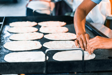 Obraz na płótnie Canvas unrecognizable woman's hands preparing flour tortillas to make bullets. honduras food concept.