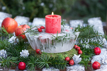 Winter-Gartendekoration mit Eislaterne und roter Kerze