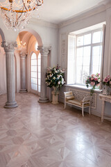 Luxurious light interior of the living room in the baroque style as in a royal castle with old stylish vintage furniture, columns, stucco on the walls