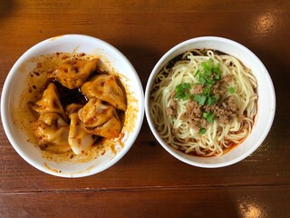 Directly above view of  Sichuan province cuisine  pork meat dumpling with red chilli oil sauce  (Chinese: Zhongshuijiao) and Dandan noodles with minced pork (Chinese: Dandanmian) in Chengdu, China