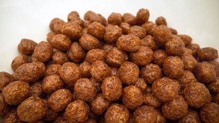 Chocolate flakes in plates. bowl with chocolate balls isolated. Chocolate rice - puffed rice-shaped chocolate flakes made from rice and wheat flour.