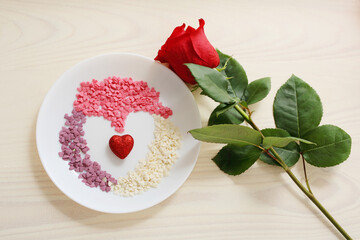 A sign of attention for a loved one. Rose flower and candy in the shape of a heart