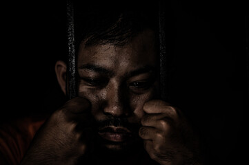 Asian man desperate at the iron prison,prisoner concept,thailand people,Hope to be free,Serious...