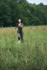 Naklejka na ściany i meble Woman in the field Fresh air of green trees is running on the grass 