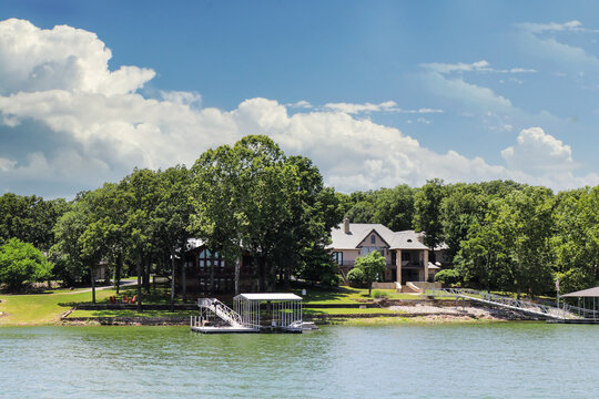 Luxury houses built beside lake with docks and little beaches among the trees