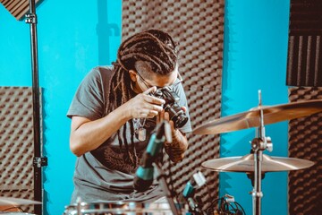 hombre con rastas sosteniendo una camara de fotos en un estudio