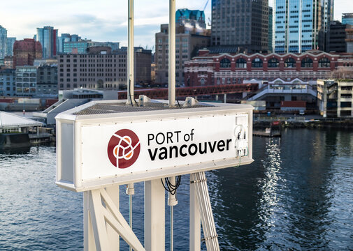 Large "Port of Vancouver" sign. Defocused Vancouver harbour area with waterfront seabus station and downtown Vancouver skyline  Selective focus.