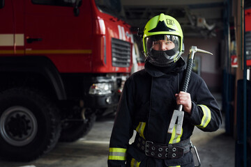 Obraz na płótnie Canvas Male firefighter in protective uniform standing near truck