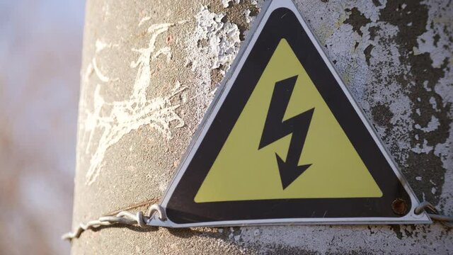 electricity safety sign on the pole next to the transformer. yellow sign lightning danger high voltage concept electricity. triangle high electricity. safe working energy with electricity