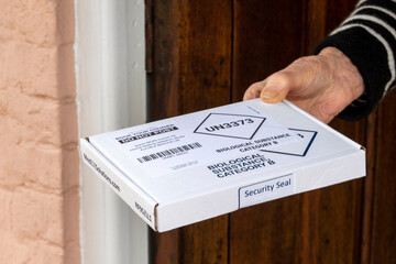 Hampshire, UK. 2021. Coronavirus, Covid-19 Home Test return box containing  biohazard bag  and test...