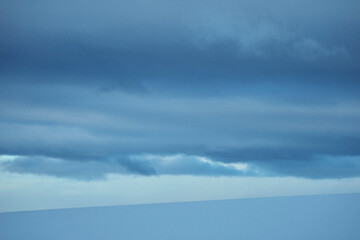 blue sky with clouds above snow covered fields in winter