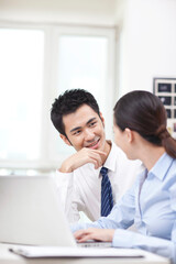 Businessman and businesswoman discussing working on computer