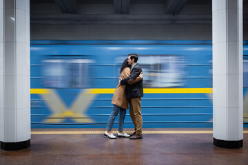 motion blur of interactional couple hugging near wagon in subway