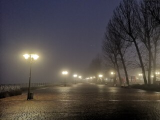 Foggy embankment lit by lanterns