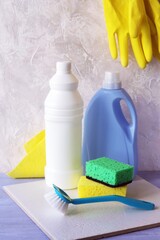 Liquid detergents in plastic bottles, packaging of home cleaning products on the table