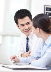 Businessman and businesswoman discussing working on computer