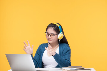 Portrait of pretty young Asian woman study wearing wireless headphones, glasses video call on...