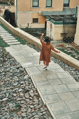 Girl on the street with a disposable paper cup. Take away food, walk around the city.