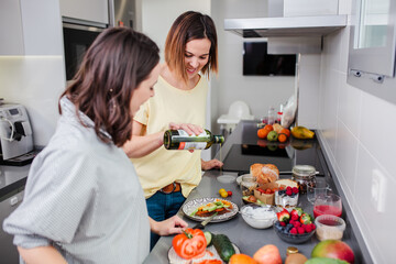Women preparing healthy food in kitchen having fun, concept dieting nutrition.