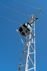 Power pole for electricity transmission and distribution in front of blue sky