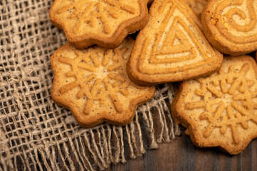 Delicious homemade cookies on a wooden table on a homespun fabric with a rough texture. Close-up selective focus.