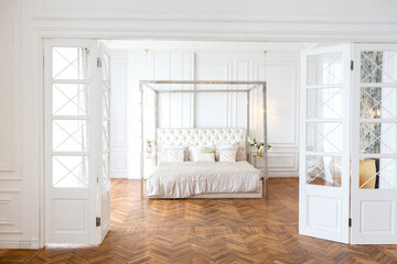 modern interior of a luxurious large bright two-room apartment. white walls, luxurious expensive furniture, parquet flooring and white interior doors