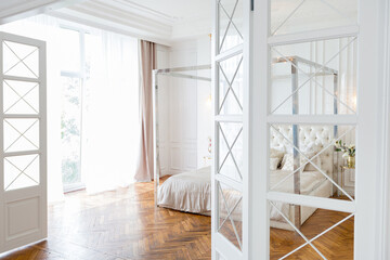 modern interior of a luxurious large bright two-room apartment. white walls, luxurious expensive furniture, parquet flooring and white interior doors