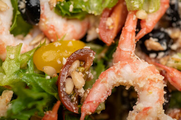 Vegetable salad with prawns and pine nuts on a plate. Homemade food. Close up.