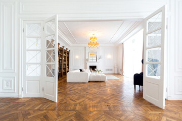 modern interior of a luxurious large bright two-room apartment. white walls, luxurious expensive furniture, parquet flooring and white interior doors