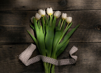 A bouquet of white tulips on a wooden background.