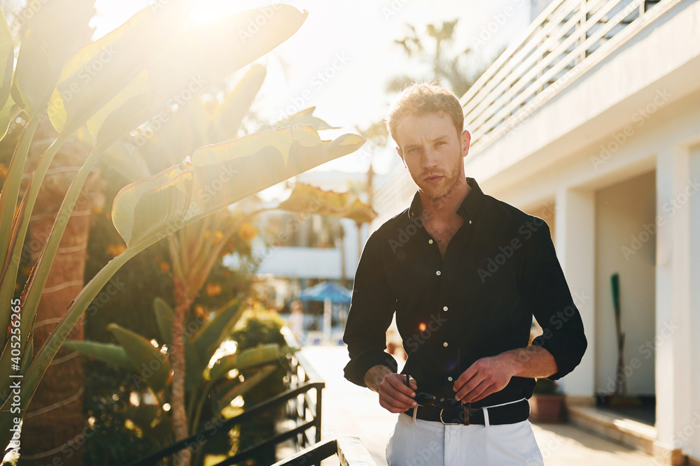 Wall mural young man is outdoors at sunny daytime. concept of vacation