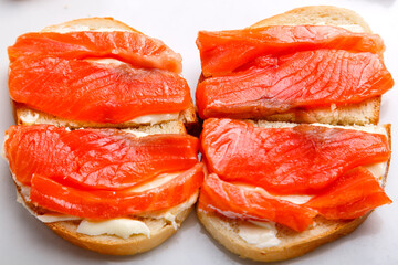 Bruschettes with butter and trout on a white plate close-up.