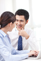 Businessman and businesswoman discussing working on computer