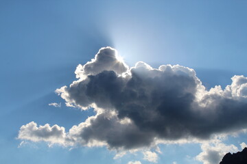Sonne strahlt hinter dunklen Wolken hervor
