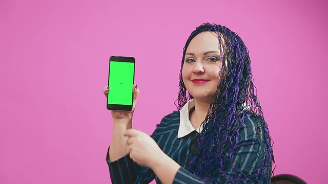 Stylish brunette jewish woman with blue afro braids leafing through the smartphone screen green screen. Medium plan