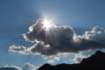 Sonne strahlt hinter dunklen Wolken hervor