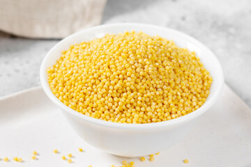 Millet. Millet in a white bowl on a light gray kitchen table