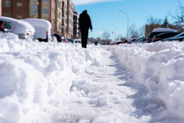 In the foreground and in focus, you can see a roll in the snow, with quite a lot of depth. In the background and out of focus, you see people and buildings 