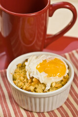 macaroni and cheese with egg sunny side up, and red cup of hot espresso, on red and white table cloth