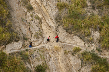 Andean highlanders crossing a landslide on the Quilotoa Loop Trek, Quilotoa, Ecuador