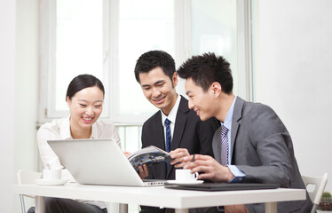 Group of businesspeople discussing with a magazine in office