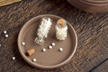 A bottle of homeopathic pills on a wooden background