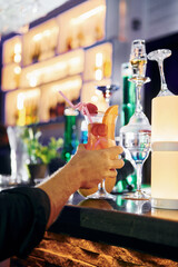 Close up focused view of man's hand that holds cocktail